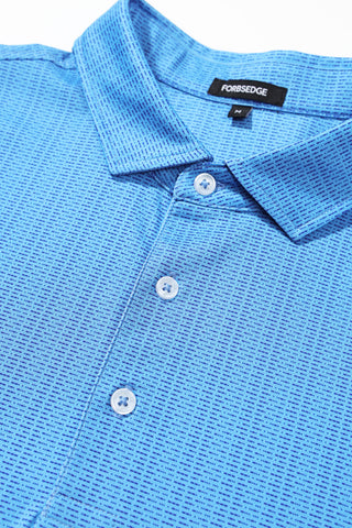 Close-up of a light blue textured polo shirt with a collar, white buttons, and a neck label.